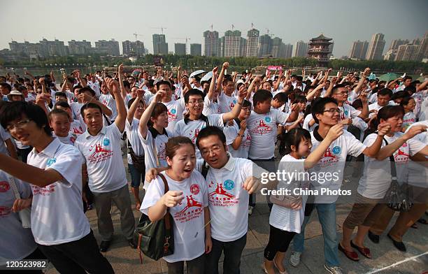 Lovers thread the eye of a needle during an activity to mark the Qixi Festival, the Chinese equivalent of Valentine's Day, at a park on August 6,...