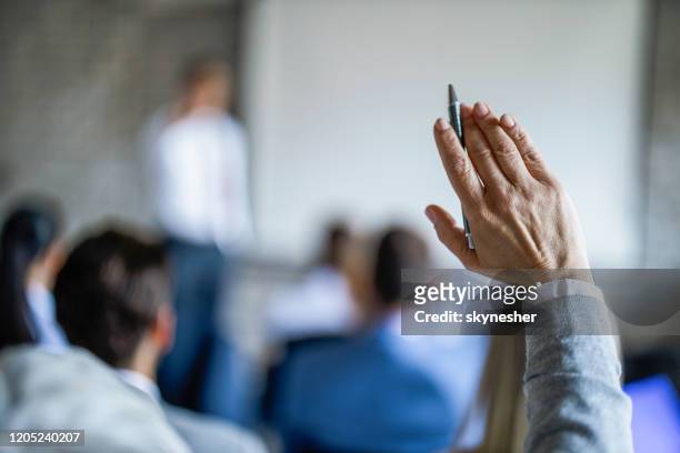 sluit omhoog van onderneemster die haar hand opheft op een seminarie in raadsruimte. - armen omhoog stockfoto's en -beelden
