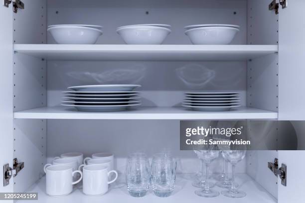 tablewares in cupboard - cabinet door stock pictures, royalty-free photos & images