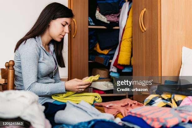 vrouw die garderobe sorteert - wardrobe stockfoto's en -beelden