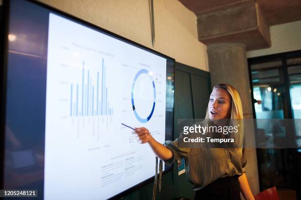 una joven empresaria haciendo un discurso de presentación. - estrategia de negocio fotografías e imágenes de stock