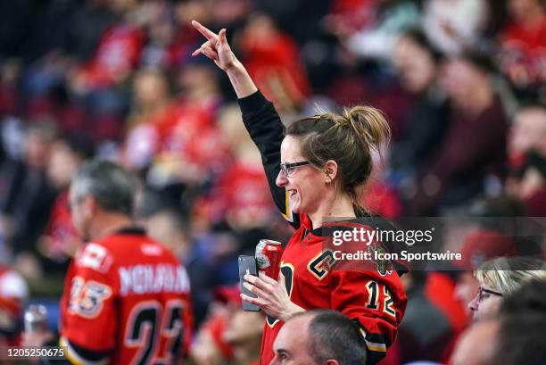 Calgary Flames fan celebrates a goal by her team during the third period of an NHL game where the Calgary Flames hosted the Columbus Blue Jackets on...