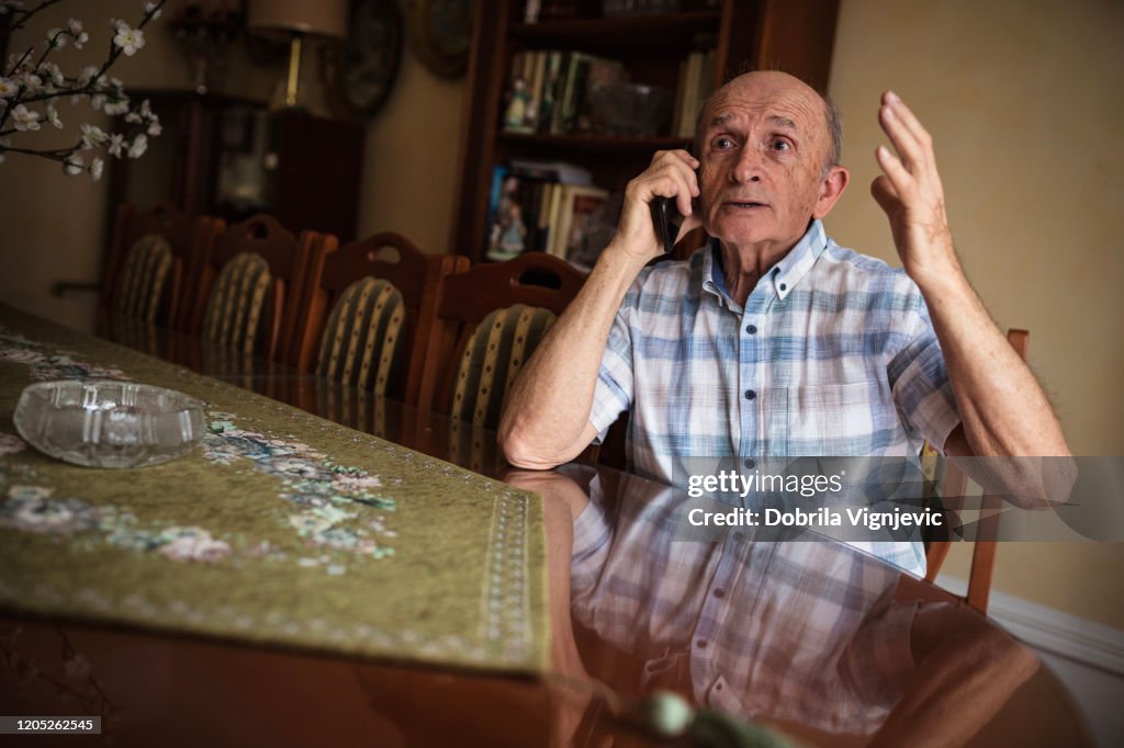Older man arguing on phone