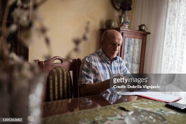 bejaarde die zijn pensioengeld in een envelop verpakt - counting stockfoto's en -beelden
