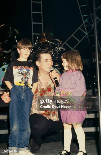 Singer Tony Hadley, of British pop group Spandau Ballet, singing to a boy and a girl, circa 1985.