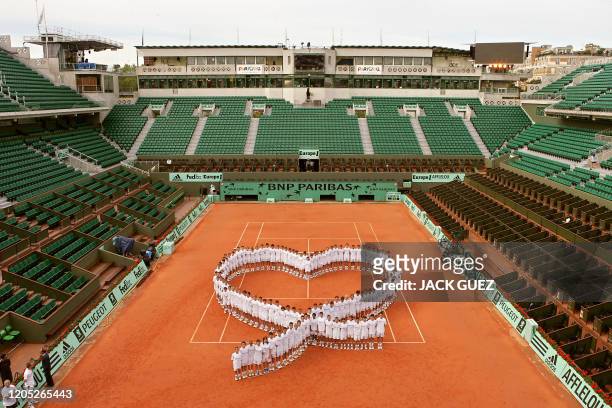 Ball boys and girls form a heart-shape illustrating the Paris 2012 logo in support for the French Bid for the 2012 Olympic Games, 31 May 2005 during...