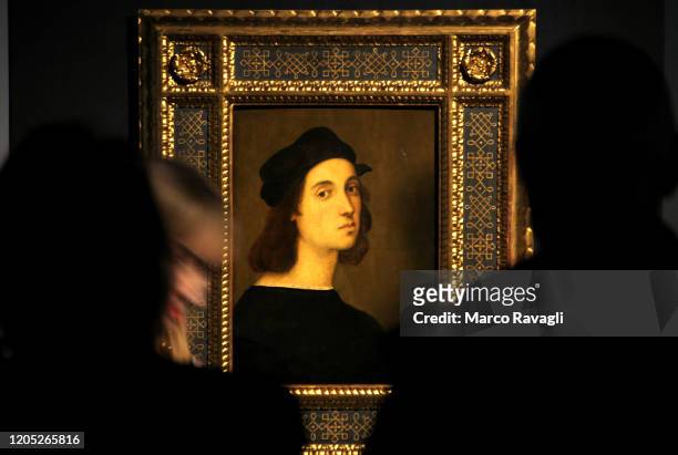 Visitor looks at the painting Self Portrait by Renaissance master Raffaello Sanzio da Urbino, known as Raphael, displayed at the exhibition Raffaello...