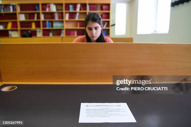 Note with prevention measures lies on a table as a student studies in an unusual empty library at the University Milano-Bicocca in Milan, on March 5,...