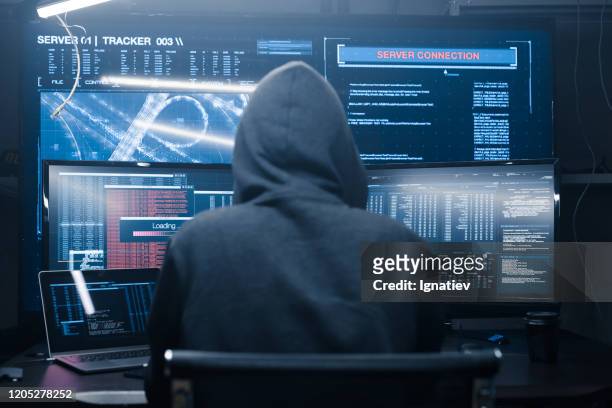 computer hacker coding on keyboard on a background of monitors. - computer hacker stock pictures, royalty-free photos & images