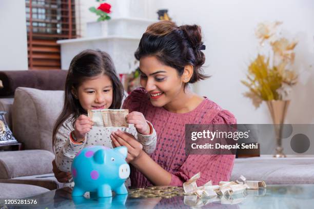 happy family mom daughter save money piggy bank future investment savings. stock photo - carefree child stock pictures, royalty-free photos & images