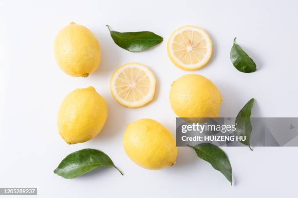 fresh lemons with leaves on white background - lemon slices stockfoto's en -beelden