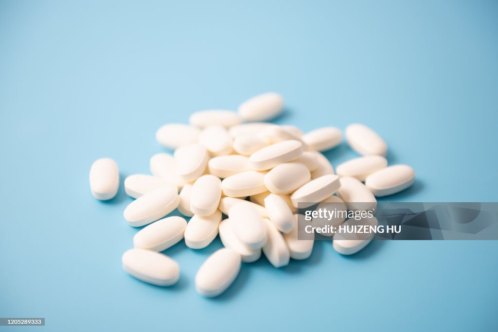White pills on blue background