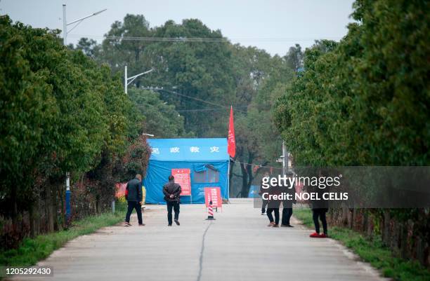Residents wearing facemasks to protect themselves against the COVID-19 coronavirus, man a checkpoint at the border of Shishou south of Hubei province...