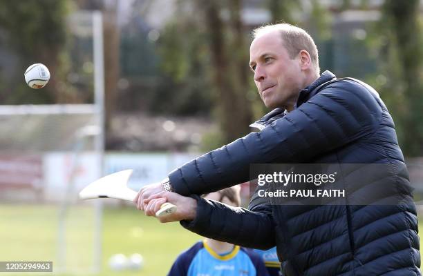 Britain's Prince William, Duke of Cambridge reacts as he attempts to play hurling during a visit to Salthill Gaelic Athletic Association club in...