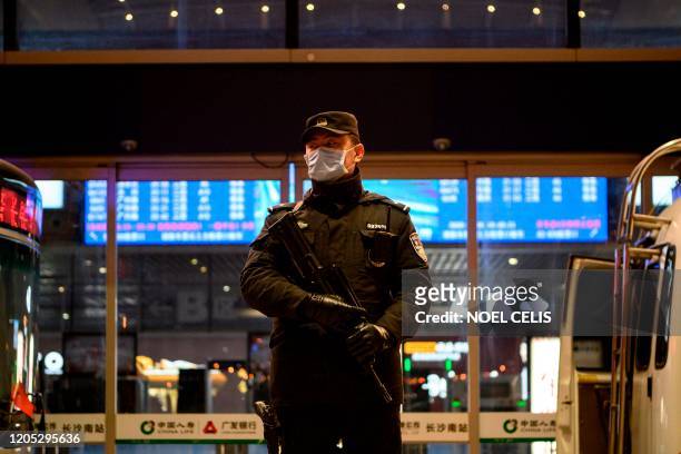 Policeman wearing a facemask as a preventive measure against the spread of the COVID-19 coronavirus stands on guard at the Changsha railway station...