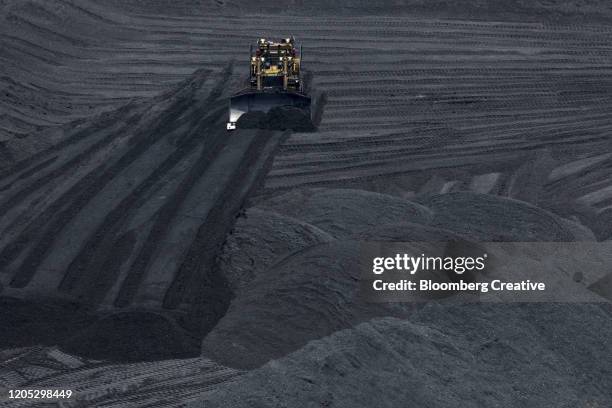 a bulldozer moves coal - coal mine stock pictures, royalty-free photos & images