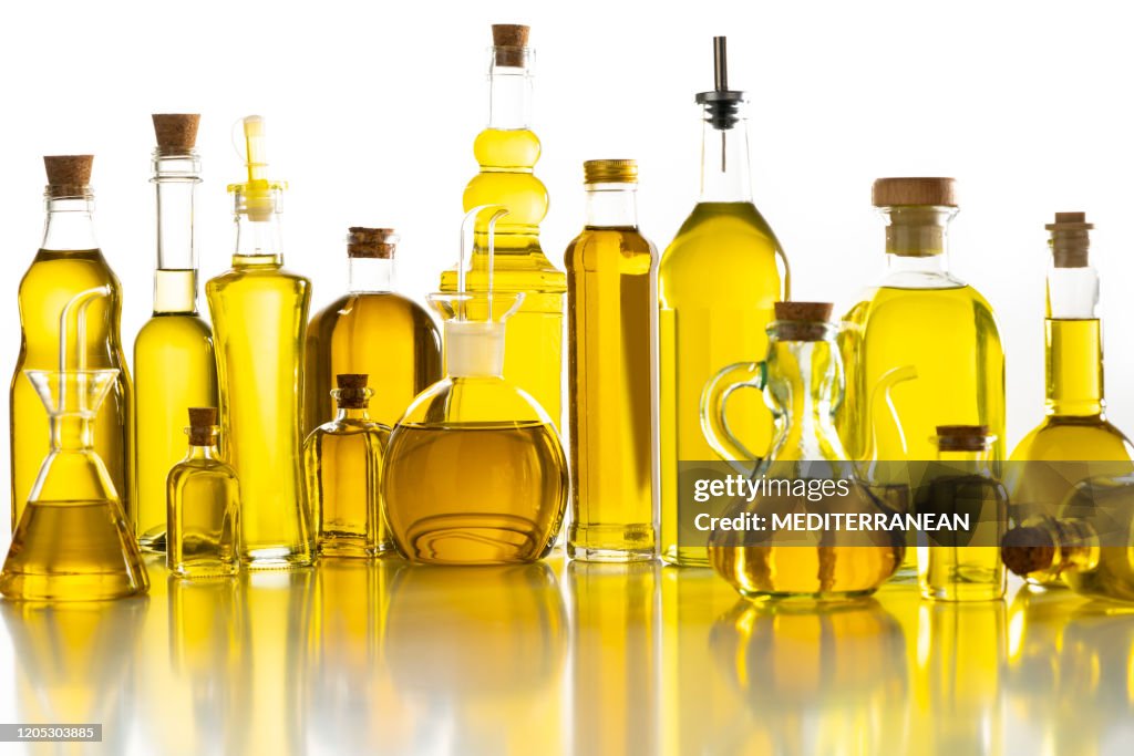 Oljeglasflaskor arrangemang i rad isolerade på vitt