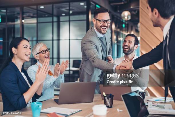 de nieuwe partners groeten - business people cheering stockfoto's en -beelden