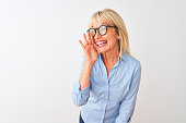 Middle age businesswoman wearing elegant shirt and glasses over isolated white background hand on mouth telling secret rumor, whispering malicious talk conversation