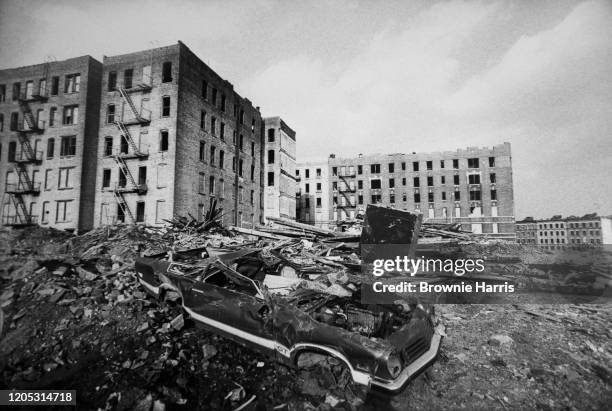 View, across a trash-strewn vacant lot, of abandoned buildings in the South Bronx neighborhood, New York, New York, 1976.