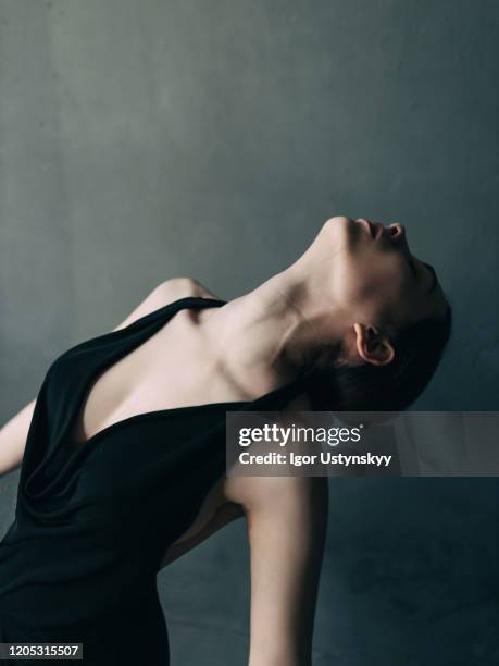 young woman ballet dancer against black background - leaning back stock pictures, royalty-free photos & images