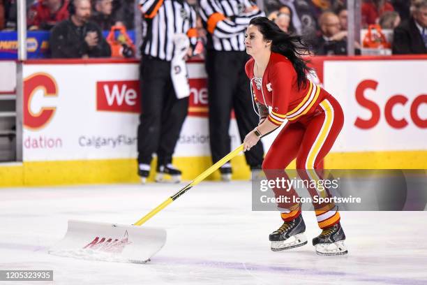 Calgary Flames ice girl cleans the ice during the second period of an NHL game where the Calgary Flames hosted the Columbus Blue Jackets on March 4...