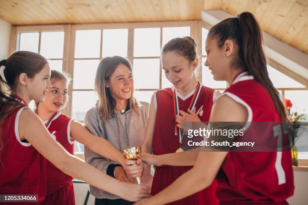 coach donna che festeggia la vittoria con la squadra di basket - sport di squadra foto e immagini stock