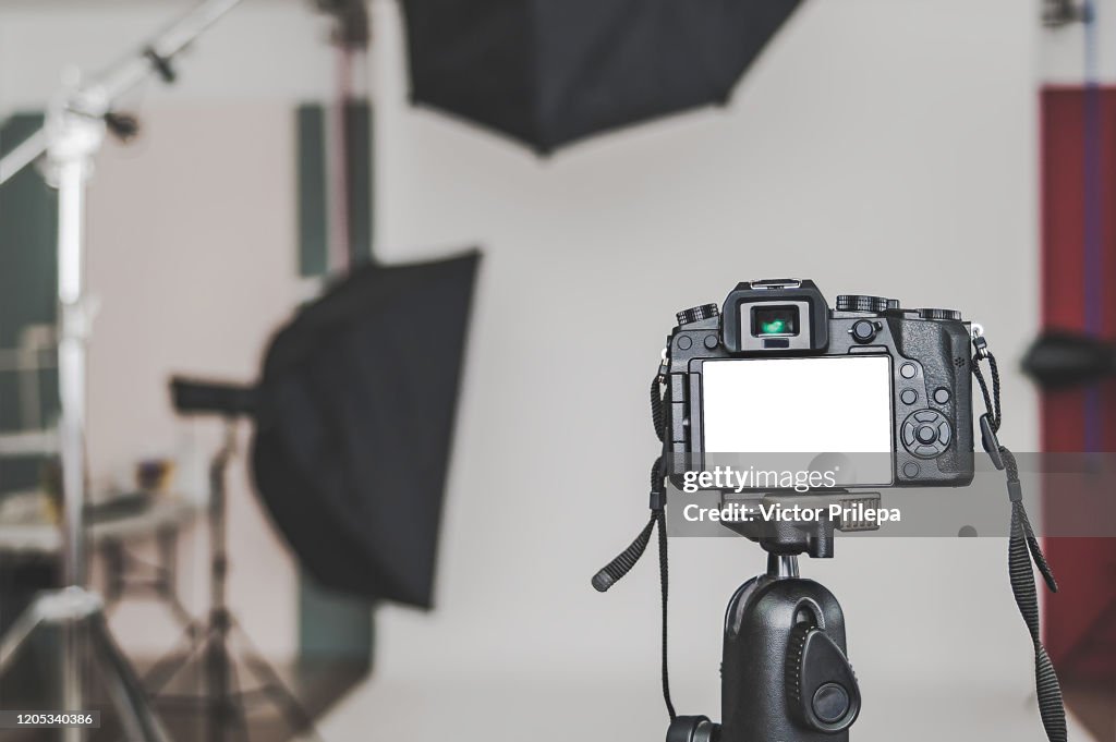 Mock up of a professional camera, in a photo studio, against the background of softbox light sources.
