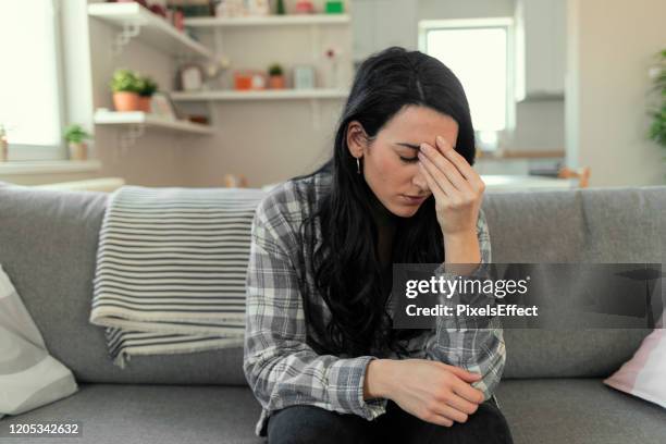 panikattacken - stressed young woman sitting on couch stock-fotos und bilder