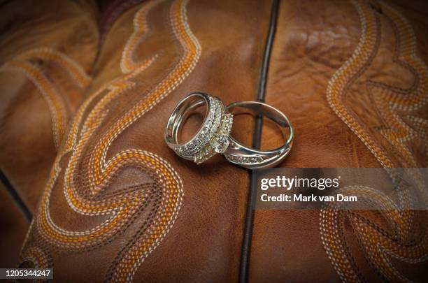 diamond wedding rings on leather cowboy boots - levenslang leren stockfoto's en -beelden