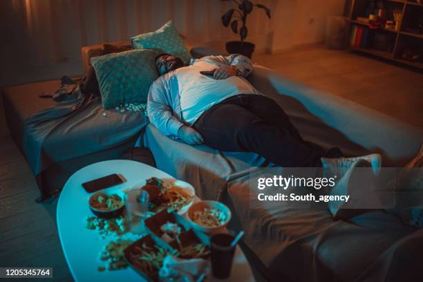 fat man sleeping on sofa - má postura imagens e fotografias de stock
