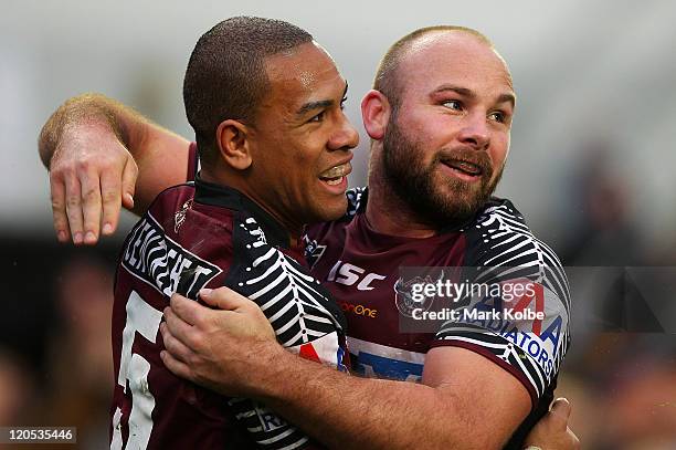 William Hopoate and Glenn Stewart of the Sea Eagles celebrate after a try during the round 22 NRL match between the Manly Warringah Sea Eagles and...