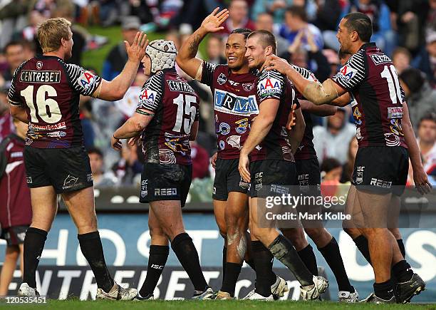 Steve Matai of the Sea Eagles is congratulated by his team mates after scoring a try during the round 22 NRL match between the Manly Warringah Sea...