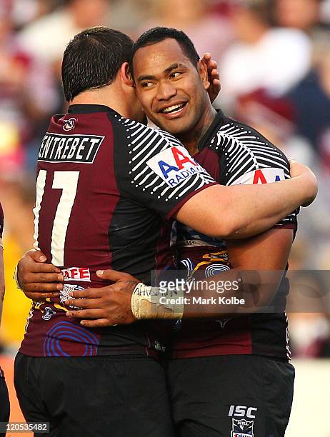 George Rose and Tony Williams of the Sea Eagles is congratulated by his team mates after scoring a try during the round 22 NRL match between the...