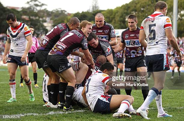 Glenn Stewart of the Sea Eagles is congratulated by his team mates after scoring a try during the round 22 NRL match between the Manly Warringah Sea...