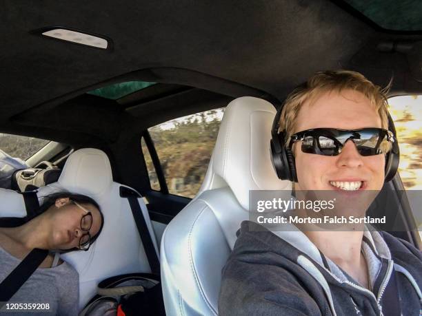 selfie of a couple on a road trip - couple sleeping in car stock-fotos und bilder