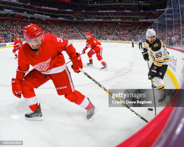 Alex Biega of the Detroit Red Wings battles in the corner for the puck with Brad Marchand of the Boston Bruins during an NHL game at Little Caesars...