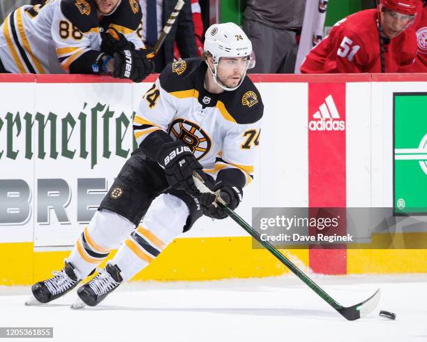 Jake DeBrusk of the Boston Bruins turns up ice with the puck against the Detroit Red Wings during an NHL game at Little Caesars Arena on February 9,...