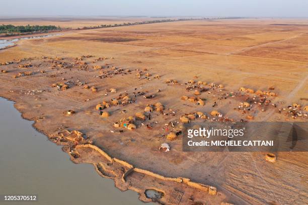 An aerial view shows a village of cattle breeders in the outskirts of Mopti in central Mali, on February 29, 2020. - Two months earlier 400 Dogon...