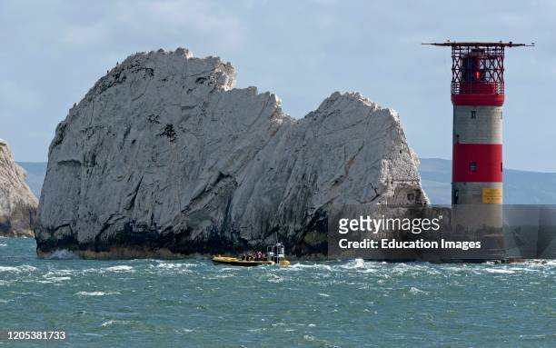 The Needles, Isle of Wight, England, UK, The Needles lighthouse with helipad situated on the outermost chalk rocks. Passengers on a rib viewing the...