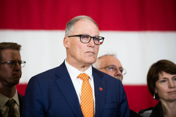 Jay Inslee, governor of Washington, listens while U.S. Vice President Mike Pence, not pictured, speaks during a joint news conference at Camp Murray...