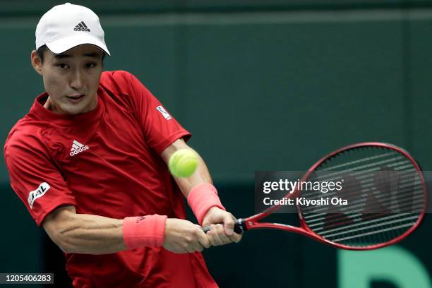 Go Soeda of Japan plays a backhand in his singles match against Emilio Gomez of Ecuador on day one of the Davis Cup qualifier between Japan and...