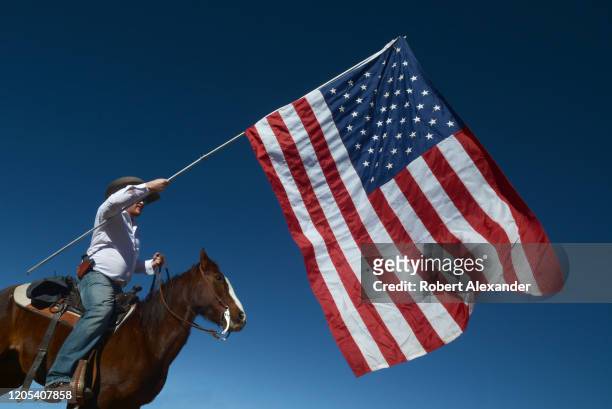 An armed member of a group calling themselves 'Cowboys for Trump' prepares to lead a group of other horse-mounted Donald Trump supporters through the...
