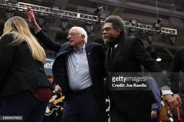 Democratic presidential candidate Sen. Bernie Sanders and political activist and author Cornel West walk onstage together during a campaign event at...