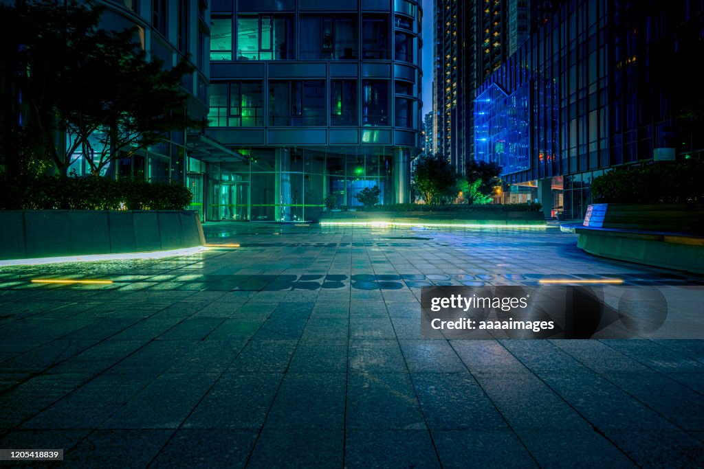 Empty pavement with modern architecture at night