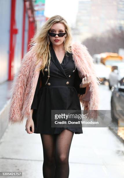 Guest is seen wearing a black dress, black heels, black sunglasses and a pink fur coat outside of the Global Fashion Collective II show at Pier59...