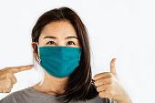 Asian woman wearing face mask to protect virus with thump up hand