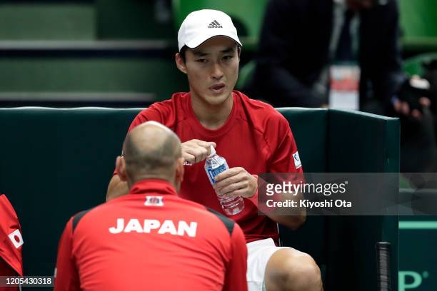 Go Soeda of Japan listens to team captain Satoshi Iwabuchi of Japan in his singles match against Emilio Gomez of Ecuador on day one of the Davis Cup...