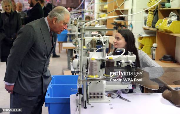 Prince Charles, Prince of Wales, as the patron of the Campaign for Wool, watches a worker sew a pair of boots during a visit to Celtic Sheepskin & Co...