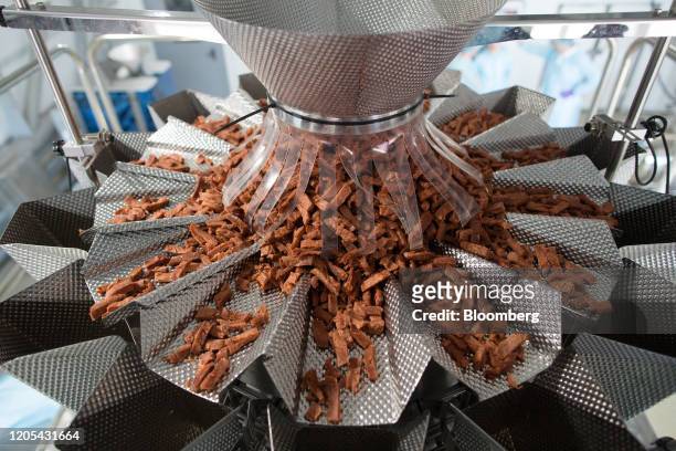 Pieces of vegetable-based meat-free beef jerky fall through a sorting machine at the Greenwise LLC plant in Maloyaroslavets, Russia, on Friday, Feb....